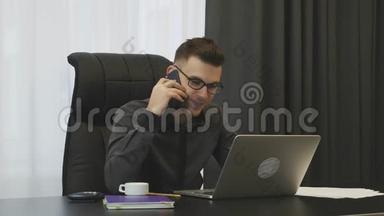 穿西装戴眼镜的人在现代办公室和客户打电话。 成功的商人与合伙人谈电话